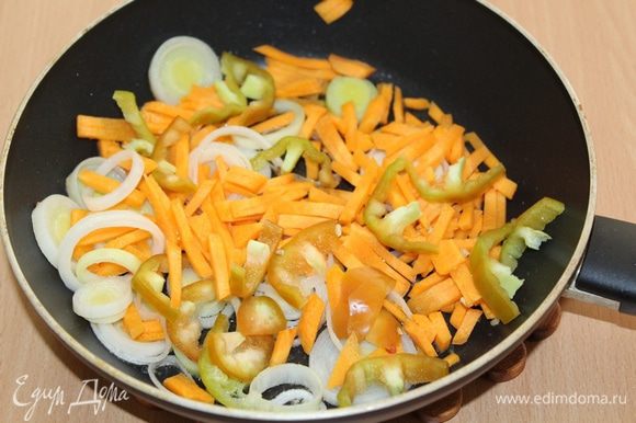 Лук-порей порезать кружочками и обжарить на растительном масле. Добавить порезанную морковь и болгарский перец, слегка поджарить.