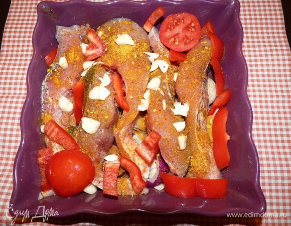 Чеснок раздавить и добавить к рыбе. Болгарский перец нарезать соломкой, уложить между рыбой. 