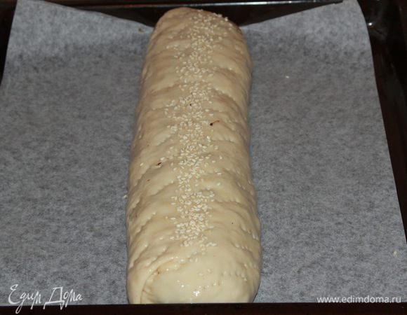 Теперь закручиваем наш штрудель полностью тестом, смазываем его растительным маслом (можно яйцом) и посыпаем кунжутом. Выкладываем на противень с пергаментом и отправляем в разогретую духовку до 180°С на 50 минут. Моя рекомендация — ориентируйтесь по своей духовке сами.