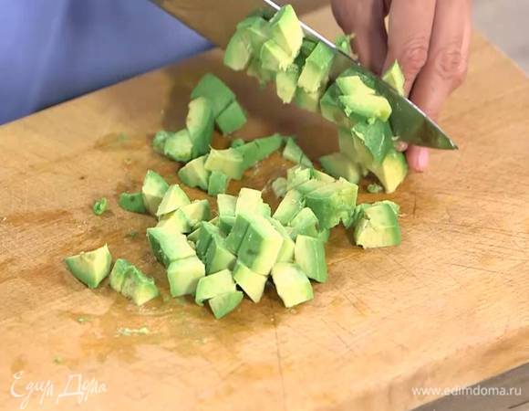 Авокадо разрезать пополам и, удалив кожуру и косточку, нарезать небольшими кубиками.