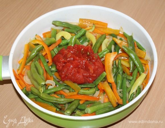 Добавить измельченные в собственном соку помидоры «Помидорка», перемешать, добавить полстакана воды, перемешать овощи и тушить 7 — 8 минут.