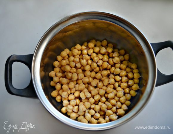 Нут необходимо хорошо промыть, залить холодной водой и оставить минимум на 3 — 4 часа, но лучше замочить его на всю ночь. Затем воду слить, залить чистой водой так, чтобы ее было примерно вдвое больше, чем нута. Поставить на огонь и довести до кипения. Пену периодически нужно снимать и продолжать варить на маленьком огне до готовности нута. У меня получилось около 2,5 ч. Когда горошины лопаются и становятся мягкими, посолить нут и оставить вариться еще на 15 — 20 минут.
