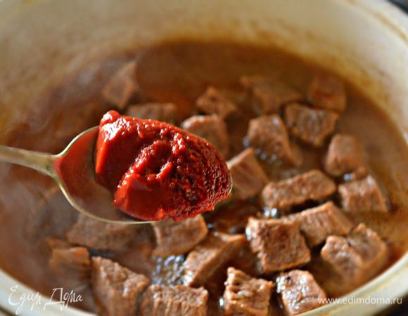 Примерно через 1 час добавить 1 ст. л. томатной пасты «Помидорка», перемешать и продолжать тушить еще 10 мин. В конце готовки почти вся вода должна  выпариться, а мясо остаться в густом мясном соусе. 