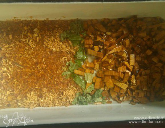 Это время разогреваем духовку до 220°С. В жаропрочную емкость засыпаем щепу ольхи, стружку можжевельника и сухие листья черной смородины. Заливаем на 1-2 см горячей водой и ставим в духовку — для придания особого аромата нашему блюду!