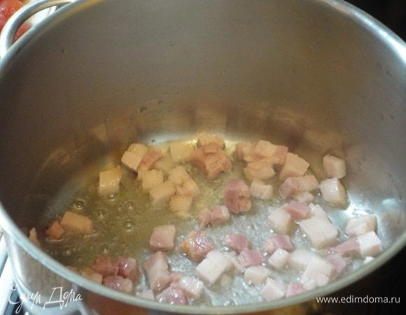 В кастрюле разогреваем оливковое масло и выкладываем грудинку, вытапливаем жир.