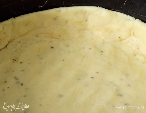 Добавить муку, щепотку соли, при желании — сухие травы (укроп, например) и замесить тесто. Оно будет мягким и теплым.
Раскатать тесто и выложить в форму диаметром 21 — 22 см. Сформировать бортики.