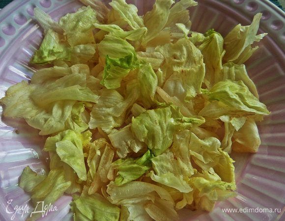 Порвать листики и уложить на дно большого блюда.