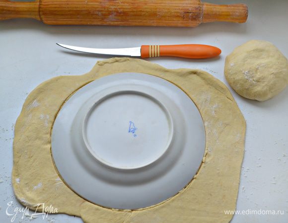 Тесто вынуть из холодильника, раскатать на пергаментной бумаге, слегка смазанной растительным маслом, и вырезать с помощью тарелки круг. 


