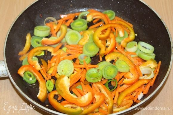 В сковороде обжарьте нарезанный лук, перец и нарезанную соломкой морковь.