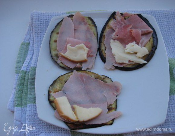 На пластинку баклажана положить ветчину и кусочек сыра.