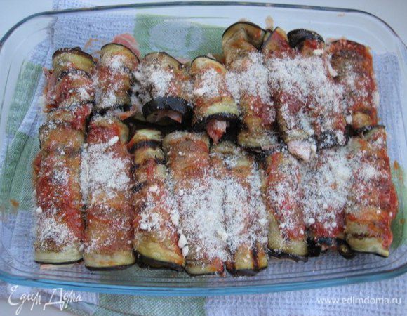 Форму для запекания смазать половиной соуса. Выложить рулетики, смазать оставшимся томатным соусом. Посыпать тертым пармезаном.
Запечь при температуре 230°С около 10 минут до румяного цвета.