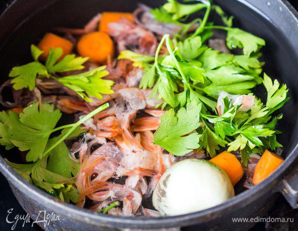 Первым делом необходимо приготовить бульон. Помыть креветки и снять с них панцирь. В кастрюл. положить панцири, крупно нарезанную морковь, лук, зелень. Поставить на сильный огонь под крышкой. Когда вода закипит, посолить и варить на небольшом огне при открытой крышке 20 — 30 минут.