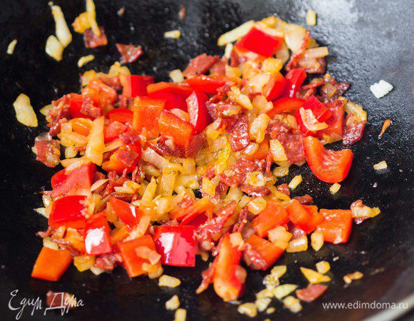 Перец нарезать кубиком. Положить его в сковороду, обжаривать минуту.