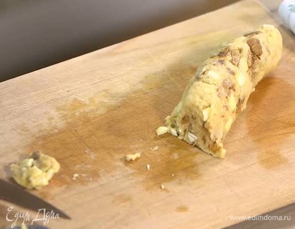 Сформировать из теста колбаску, затем нарезать ножом на небольшие лепешки и выложить на противень, выстеленный бумагой для выпечки.