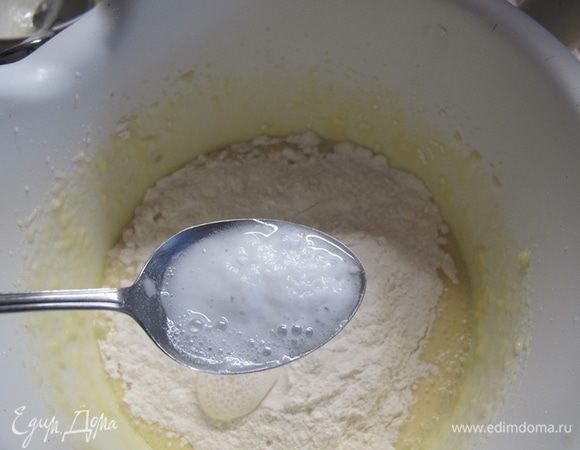 Всыпьте в миску часть муки и добавьте соду, гашеную лимонным соком (или яблочным уксусом).

