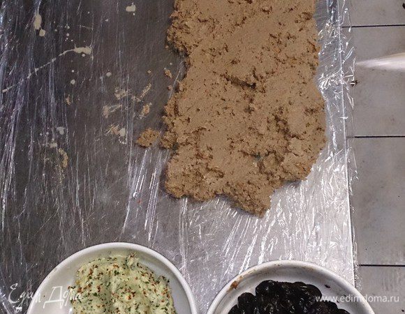 На пищевую пленку выкладываем равномерным слоем паштет, подготавливаем масло с зеленью, горчицей, чесноком и чернослив, замаринованный (минут 10) в арманьяке.