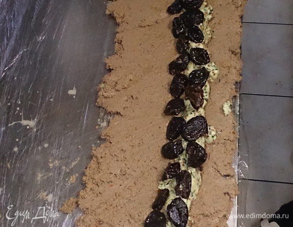На слой паштета выкладываем колбаской масло, и целиковый чернослив.