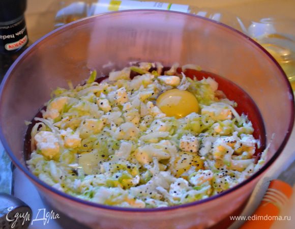 За это время кабачки уже достаточно хорошо пустили сок, натертую мякоть необходимо отжать. В миске смешать кабачки, лук, добавить яйца и кубики сыра. Слегка поперчить.