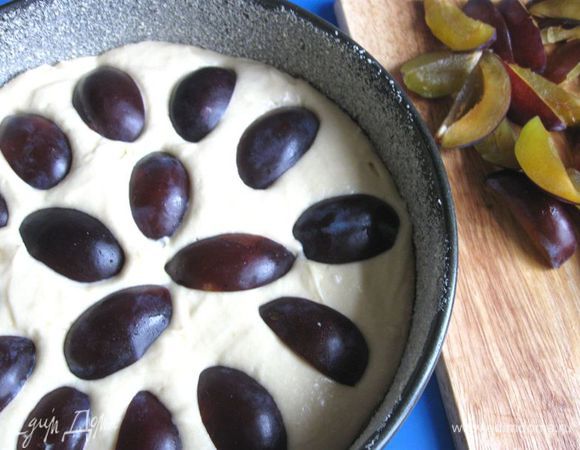 Сверху поместить сливы кожурой к поверхности пирога, слегка вдавливая сливы в тесто. 