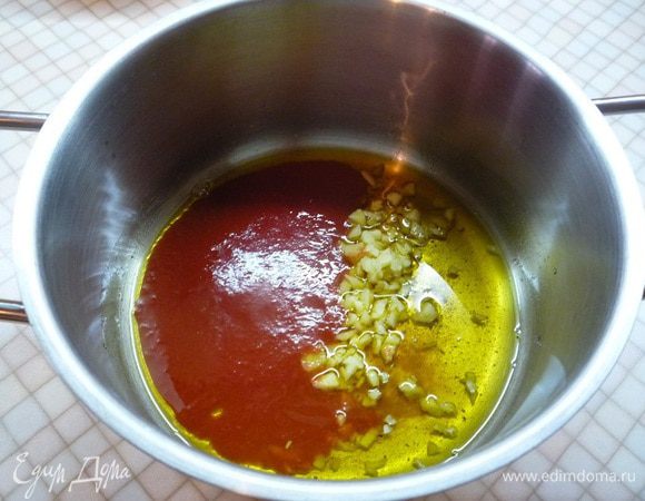 В кастрюлю с толстым дном наливаем растительное масло и разогреваем его. Добавляем куркуму, мелко нарезанный имбирь, томатную пасту и обжариваем 1 — 2 минуты.