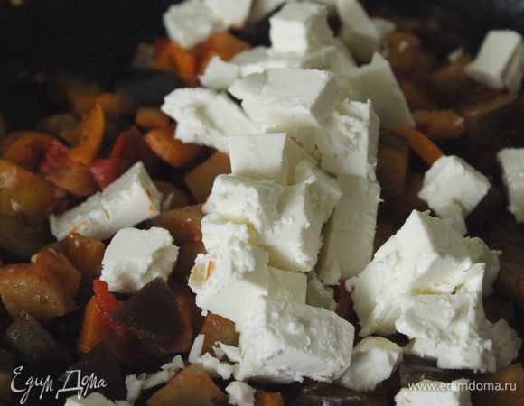 Сыр фета нарезать кубиками, добавить к овощам и перемешать.