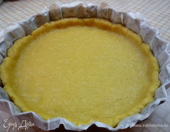 Вынимаем тесто из холодильника, даем ему дойти до комнатной температуры, чтобы с ним было легко работать. Раскатываем на листе пергамента по диаметру формы, примерно 28 см, шириной примерно 3 мм. Выпекаем в разогретой духовке при температуре 180°С 20 минут до румяного цвета.