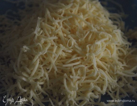 Через 15 мин посыпать начинку натертым сыром, а сами лодочки (тесто) смазать желтком. Выпекать еще минут 10.