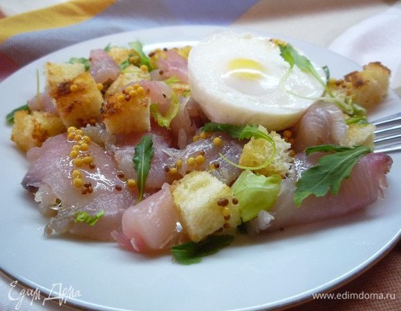 Руколу моем, подсушиваем на кухонном полотенце, смешиваем с 2 ст. л. заправки и раскладываем в салатники. Копченое филе сома нарезаем небольшими кусочками и добавляем к руколе вместе с крутонами. Сверху укладываем яйца и поливаем оставшейся заправкой. Приятного аппетита!