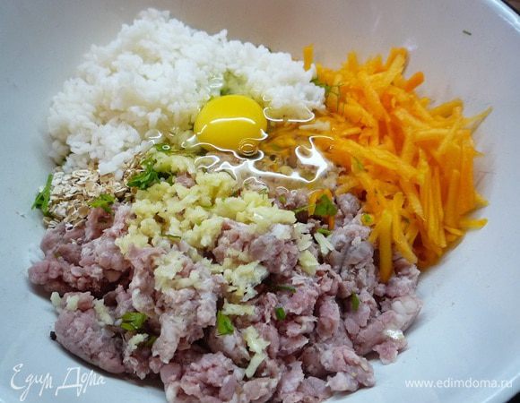 В фарш добавляем мелко рубленную зелень, отваренный до полуготовности рис, яйцо, чеснок, овсяные хлопья, натертую на крупной терке тыкву. Солим, перчим.