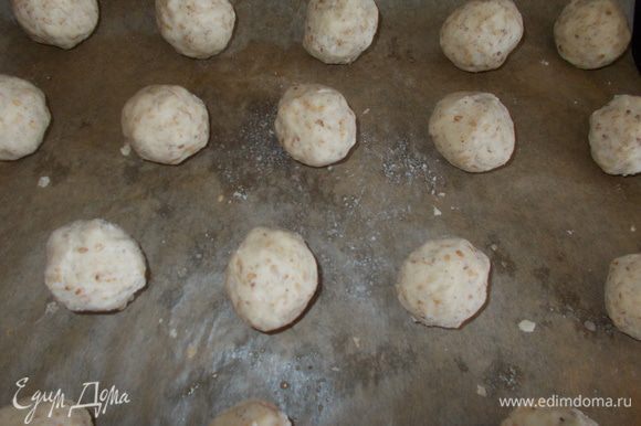 Сделать шарики размером с грецкий орех, выложить на застеленный пекарской бумагой противень.
