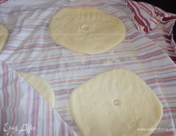 Разделить тесто на 4 одинаковые части. Присыпать полотенце семолиной (обязательно), каждую часть сделать лепешкой толщиной в 1,5 см, сверху присыпать семолиной, посредине сделать дырку или при приготовлении проколоть вилкой в 4 местах. Опять накрыть и оставить на 30 мин. 