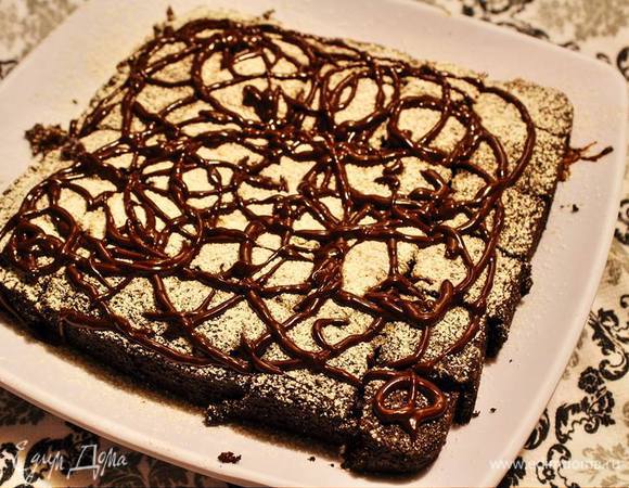 Готовый брауни остудить немного в форме, еще теплым выложить на тарелку, полить глазурью (я для узора сначала немного притрусила снежком из сахарной пудры), и можно есть. 