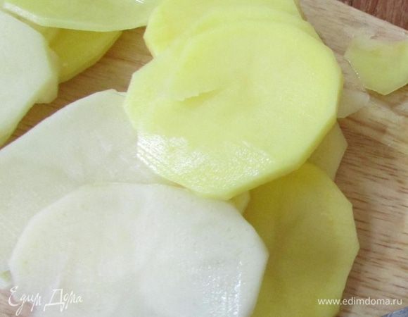 Картофель почистить и нарезать тонкими слайсами.