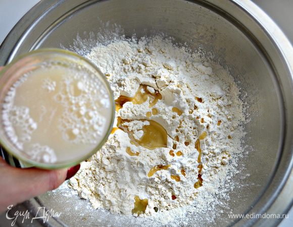 Сделать в муке углубление, влить оливковое масло, а затем постепенно добавить растворенные с медом дрожжи. Замесить тесто, накрыть чистым льняным полотенцем и поставить в теплое место на 1 час.