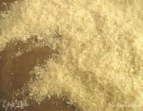 В блендере использовать пульсирующий режим, секунд 10-15 измельчать, встряхнуть стакан блендера, перевернуть, вернуть в исходное положение, еще немного измельчить, если остались большие кусочки хлеба. Нам нужна не очень мелкая, фактурная  крошка. Духовку разогреть до 120°С (можно поставить чуть меньше градус). Противень застелить бумагой для выпечки, выложить измельченный хлеб, поместить в духовку, надо периодически перемешивать крошку, можно через небольшое время приоткрыть дверцу духовки, продолжать высушивание. Крошка должна остаться светлой. Она должна получиться сухой, пушистой, легкой.