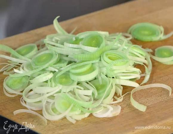 Светлую часть лука-порея нарезать тонкими кольцами.