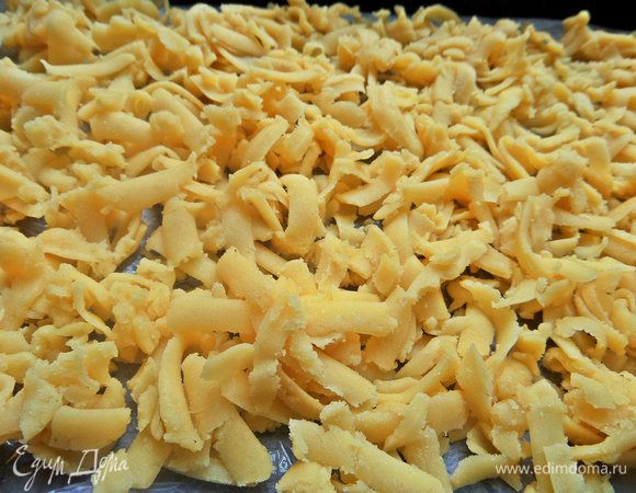 Застилаем форму (17 см на 31 см) промасленной бумагой для выпечки и насыпаем ровным слоем тертое тесто.