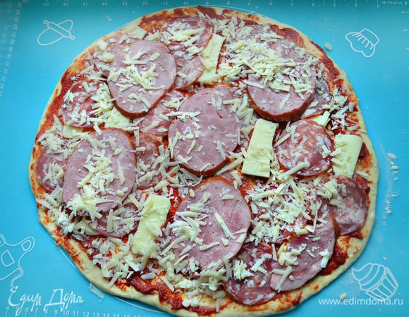 Сверху, чередуя, уложите колбасу, ветчину, моцареллу и тертый сыр.