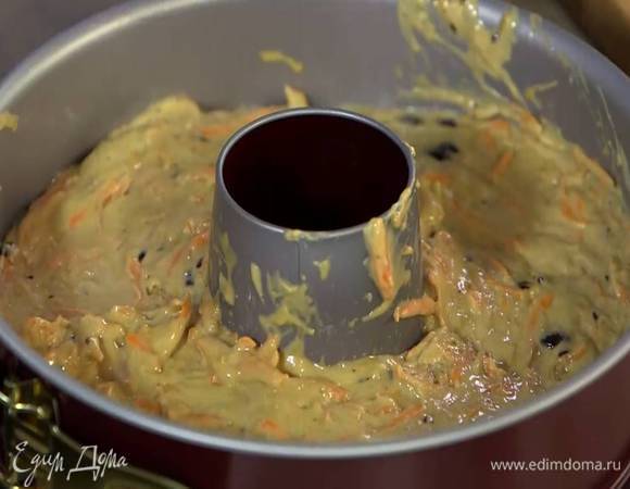 Разъемную форму для кекса с выемкой посередине смазать оставшимся оливковым маслом и равномерно выложить тесто.