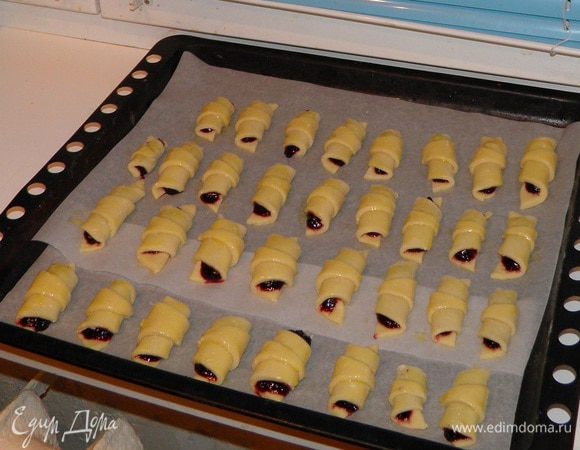 Рогалики выложите на смазанный маслом противень или пекарскую бумагу. Верх рогаликов смажьте желтком (по желанию). Поставьте в разогретую духовку, выпекайте 15–20 минут при температуре 180°С.