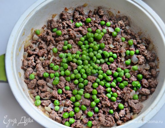 Добавьте размороженный зеленый горошек. Посолите, поперчите, перемешайте и протушите в течение 5 минут.