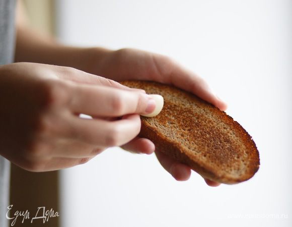 Поджариваем два больших куска хлеба. Затем берем зубчик чеснока и натираем тосты. Аромат невероятный!