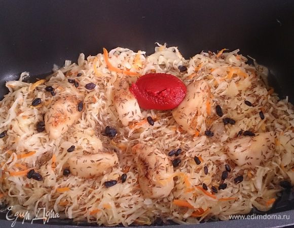 Выкладываем в емкость для тушения капусту, яблоки, добавляем тмин, барбарис, томатную пасту и наливаем яблочный сок.