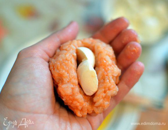 Из остывшего ризотто мокрыми руками формируем шарик с углублением, кладем внутрь моцареллу, закрываем ризотто сверху. 
