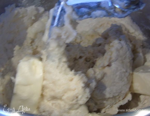 Добавьте теплое молоко и воду, и продолжая замешивать, постепенно вмешивайте по кусочку размягченное сливочное масло. Накройте полотенцем и оставьте на 1 час подойти.