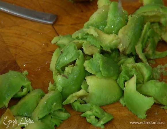 Авокадо разрезать пополам и удалить косточку, мякоть вынуть ложкой и сбрызнуть половиной сока лайма.