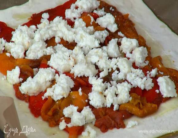 Внутренний прямоугольник теста смазать оливковым маслом, выложить полоски перца, сверху разложить раскрошенный руками козий сыр.