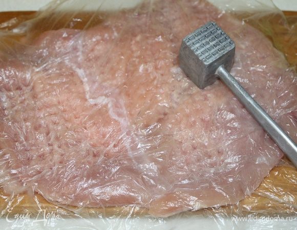 Грудку индейки накрыть пленкой и отбить в виде тонкого и широкого листа, чтобы можно было свернуть в рулет. Посолить, поперчить с двух сторон.