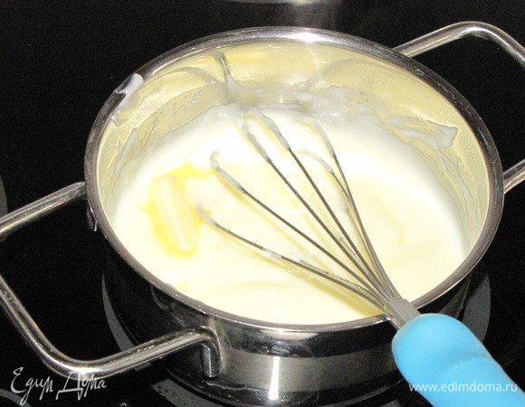 Полученную массу влить в кипящее молоко, интенсивно мешая венчиком. Варить до загустения, помешивая. Снять с огня, добавить сливочное масло и несколько капель ванильной эссенции, размешать до растворения масла.
