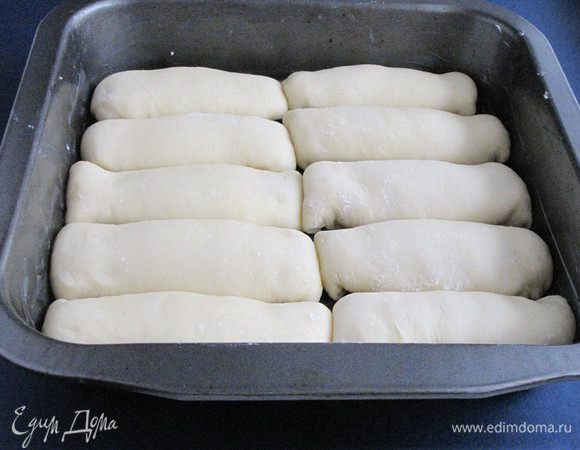 Взять форму размером 25х25 см или 20х30 см. Смазать ее сливочным маслом и выложить булочки, близко друг к другу.
